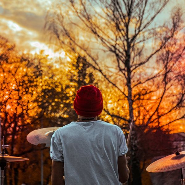 Silhouette of a man stretching against a vibrant sunrise.